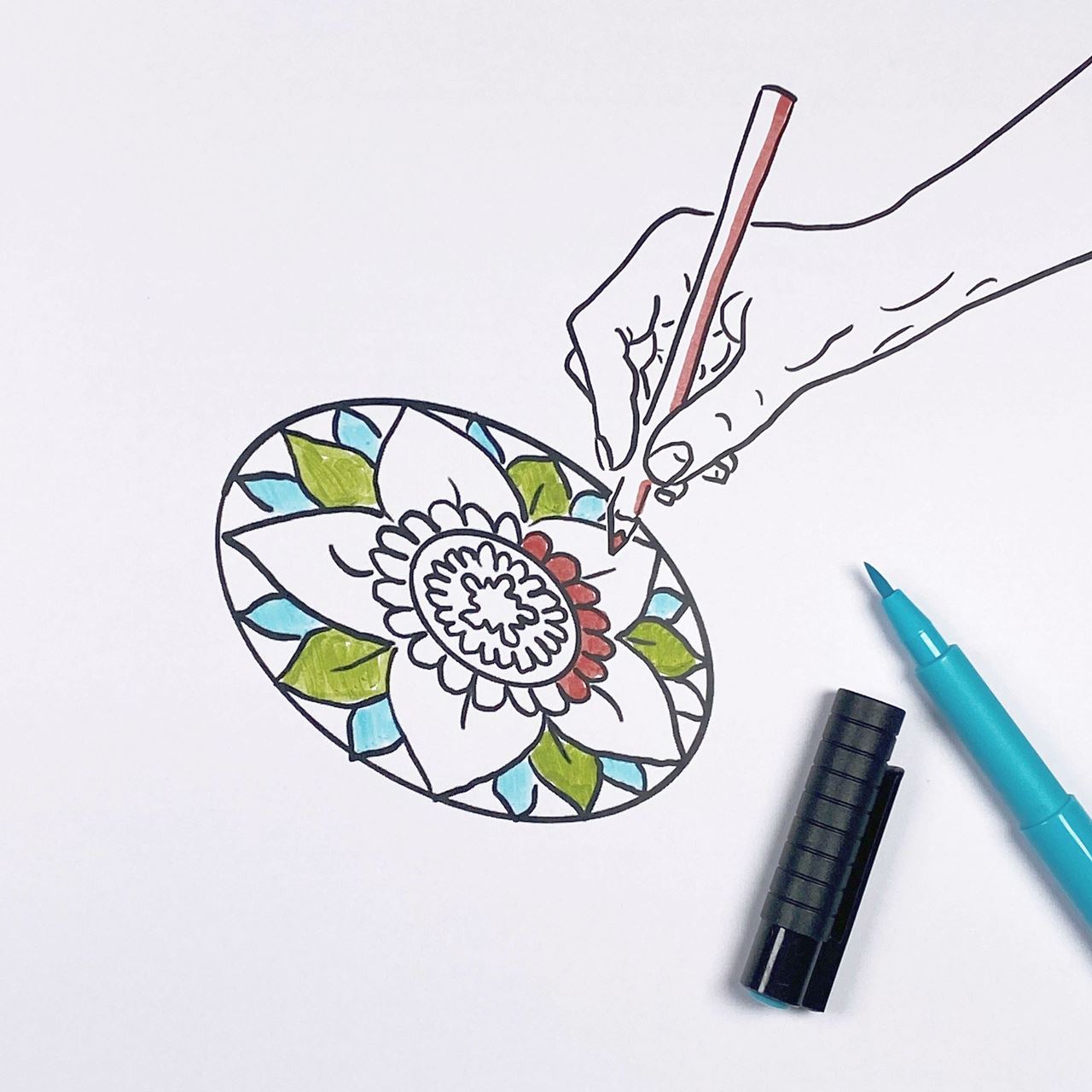 sketch of a mandala with a hand holding a pen